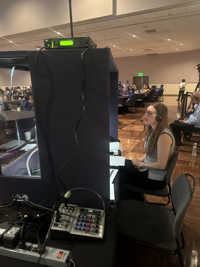 Professional interpreter delivers live translation from a sound booth, bridging language gaps for an international audience.