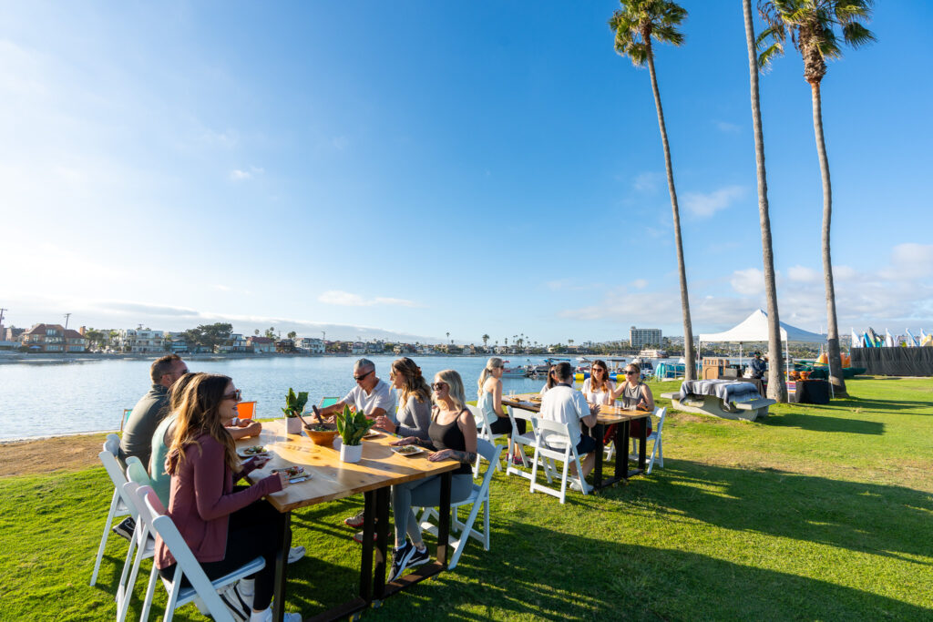 Professional language services team meeting outdoors at waterfront tables in San Diego.